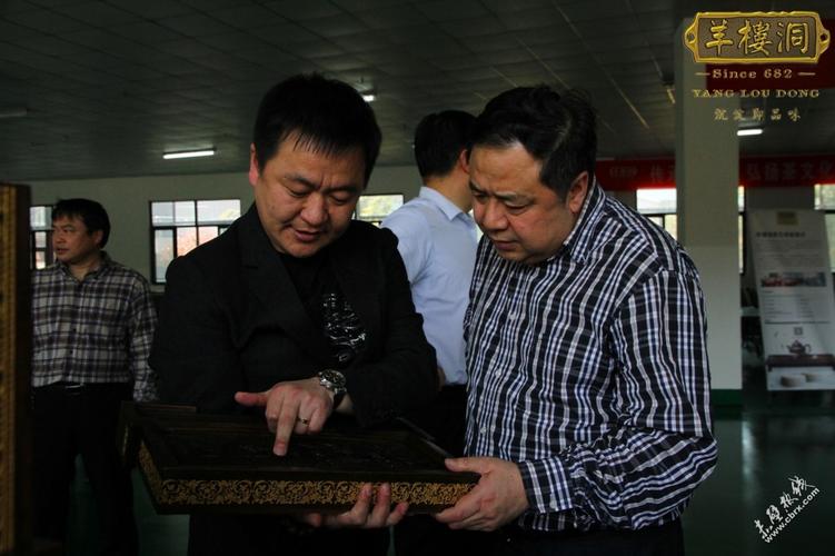 羊楼洞茶业董事长刘建军(左-1)在向许克振(右-1)介绍国礼产品.